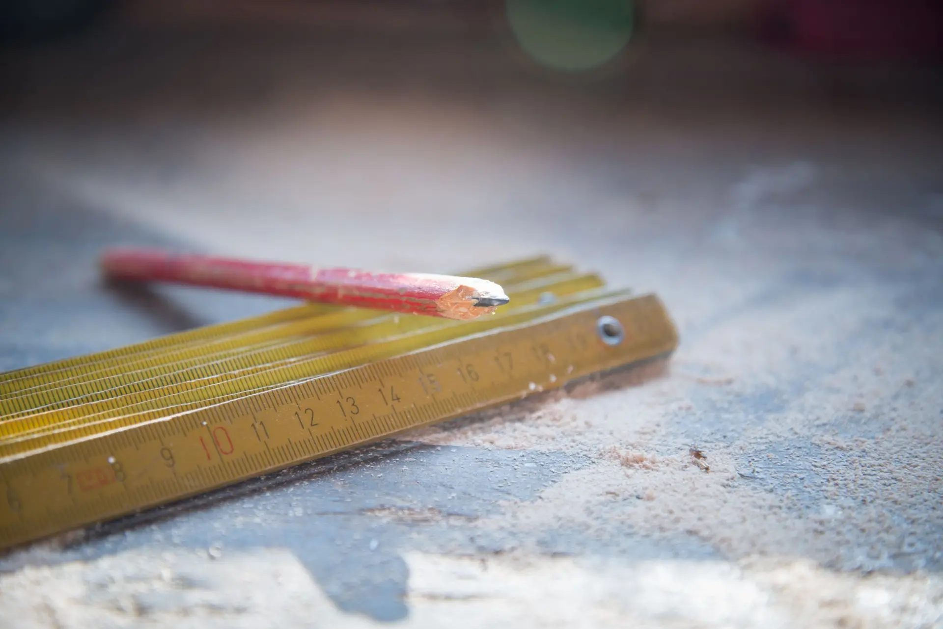 Folding wooden ruler and a pencil on a work surface