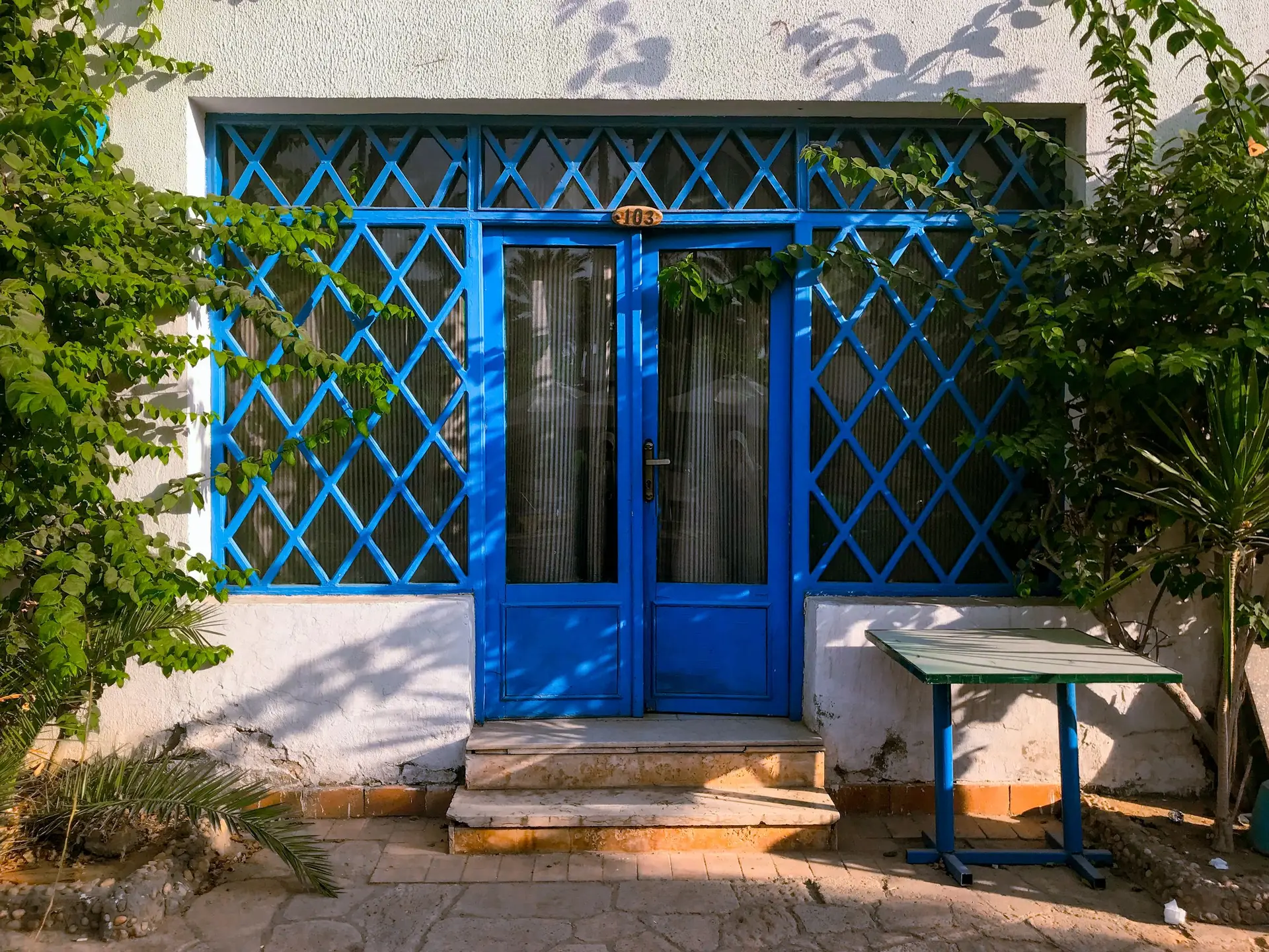 Pair of blue glazed doors behind a blue lattice screen